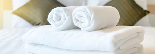 Folded linens from hotel of vacation rental on a bed